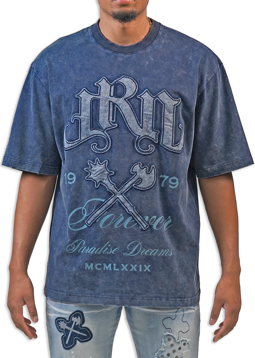 Man wearing a blue acid wash graphic t-shirt with text and design elements.