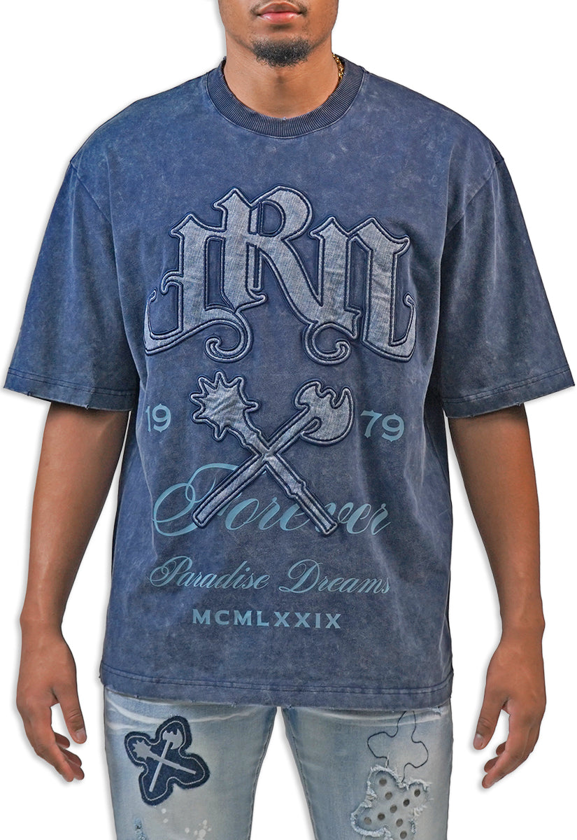 Man wearing a blue acid wash graphic t-shirt with text and design elements.