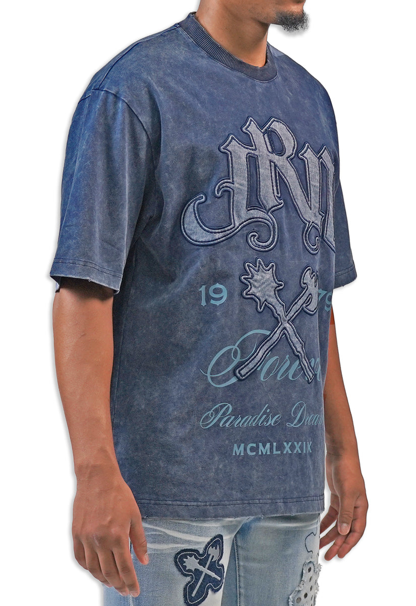 Person wearing a blue acid wash  t-shirt with graphic design and text JRN Battle Axe Logo with the words Forever Paradise Dreams.