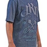 Person wearing a blue acid wash  t-shirt with graphic design and text JRN Battle Axe Logo with the words Forever Paradise Dreams.