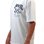 Person wearing a white t-shirt with navy text and graphics on a white "Juren 1979 Logo.