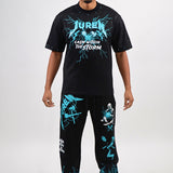 Man wearing a black t-shirt and pants with teal & white graphics on a black background