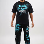 Man wearing a black t-shirt and sweat pants with teal & white graphics on a white background