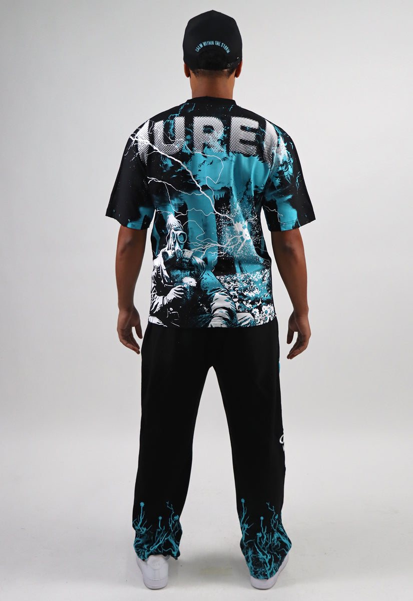 Man wearing a black t-shirt and sweat pants with teal & white graphics on a white background