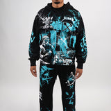 Person wearing a black and teal graphic hoodie and pants set on a white background