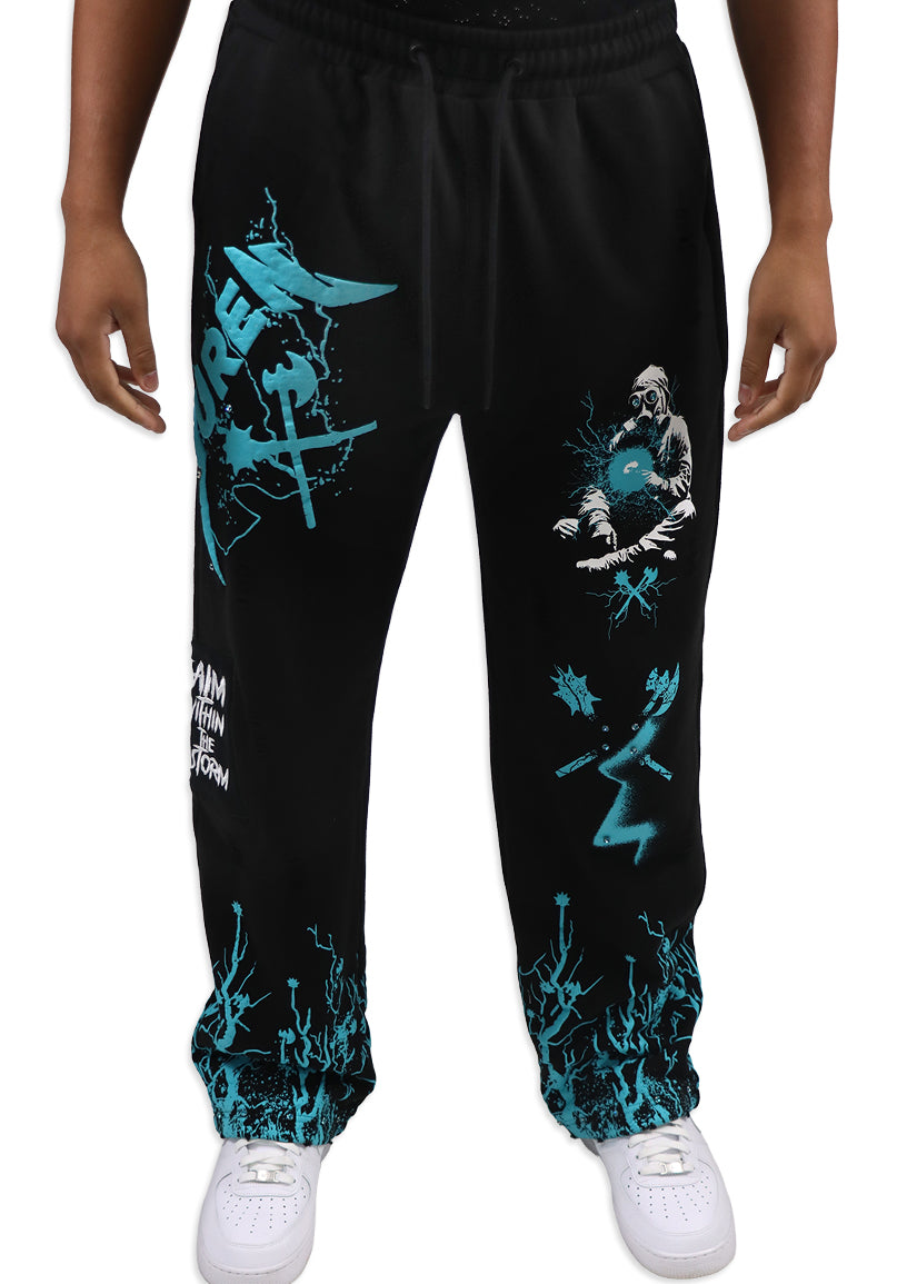 Black sweatpants with teal graphics worn by a person on a white background