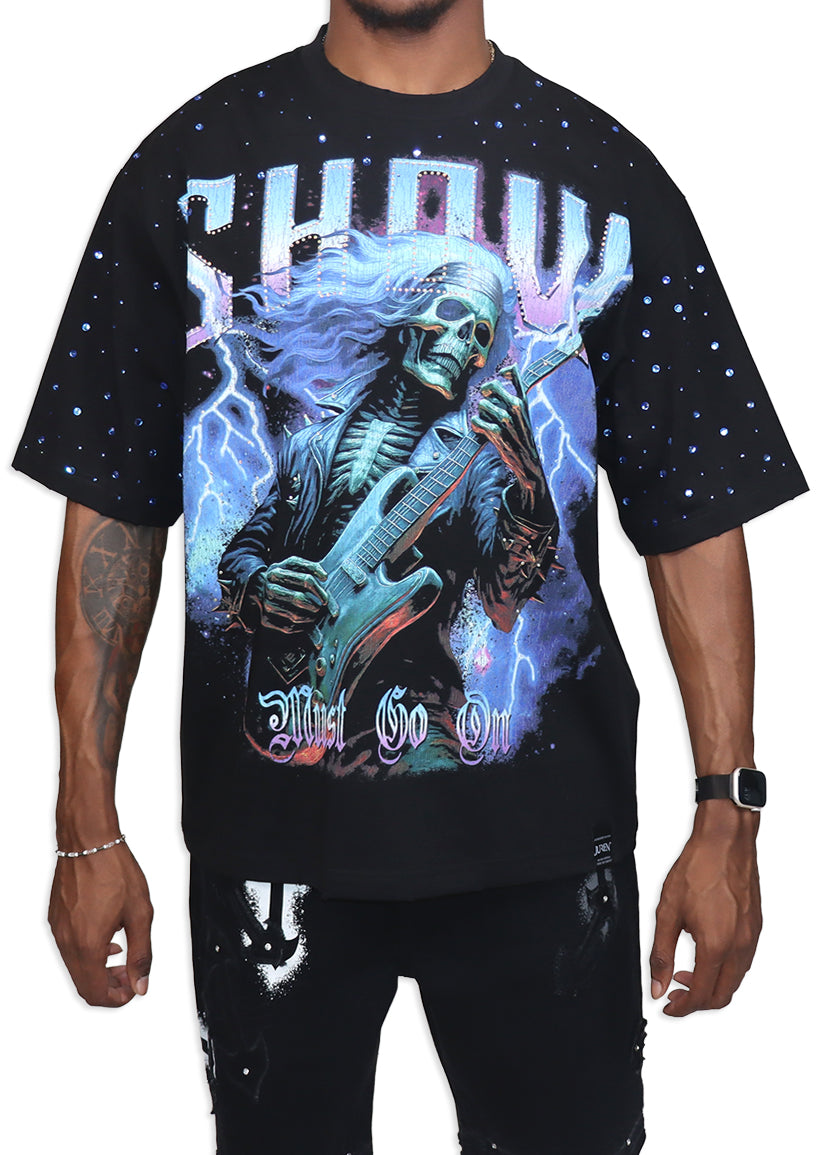 Black t-shirt with a graphic design of a skeleton playing guitar against a starry sky, worn by a person.