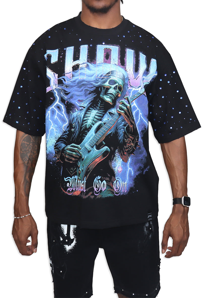 Black t-shirt with a graphic design of a skeleton playing guitar against a starry sky, worn by a person.