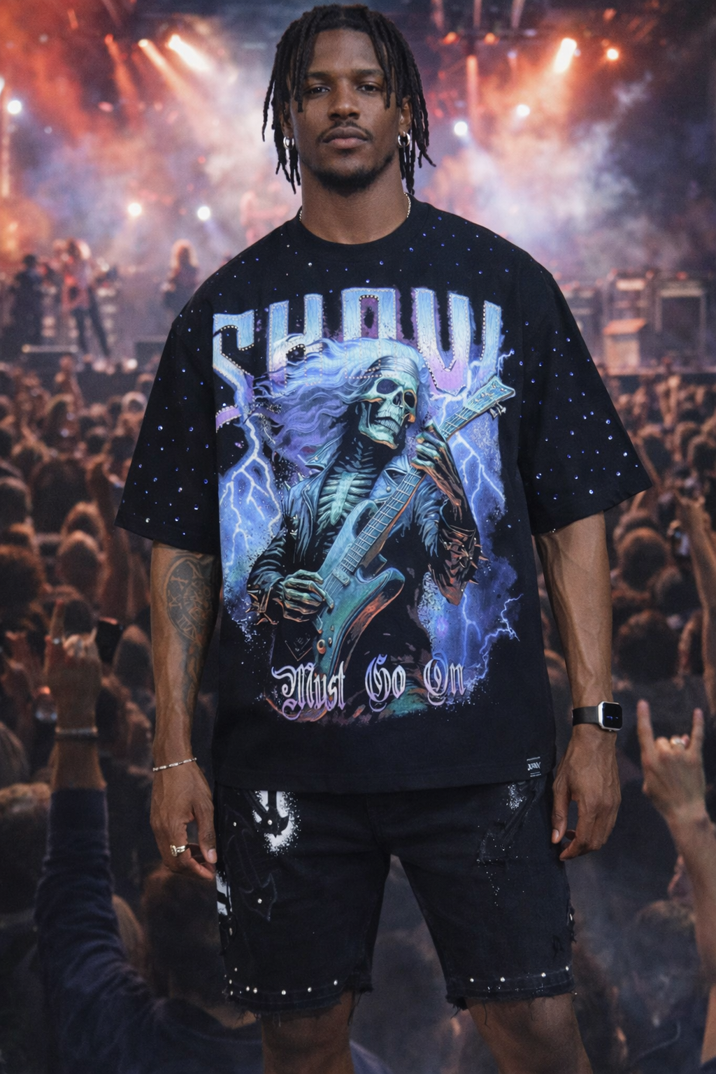 Person wearing a black t-shirt with a graphic design in front of a concert crowd.